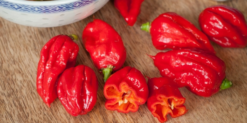 Red Carolina Reaper chillies on wooden table